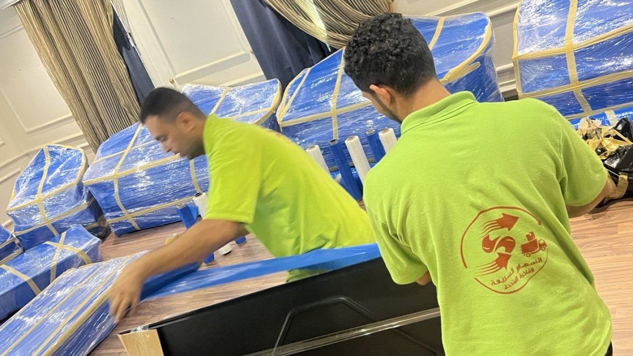 فريق السهام يجهز قطعة أثاث أمام قطع مغطاة للحماية